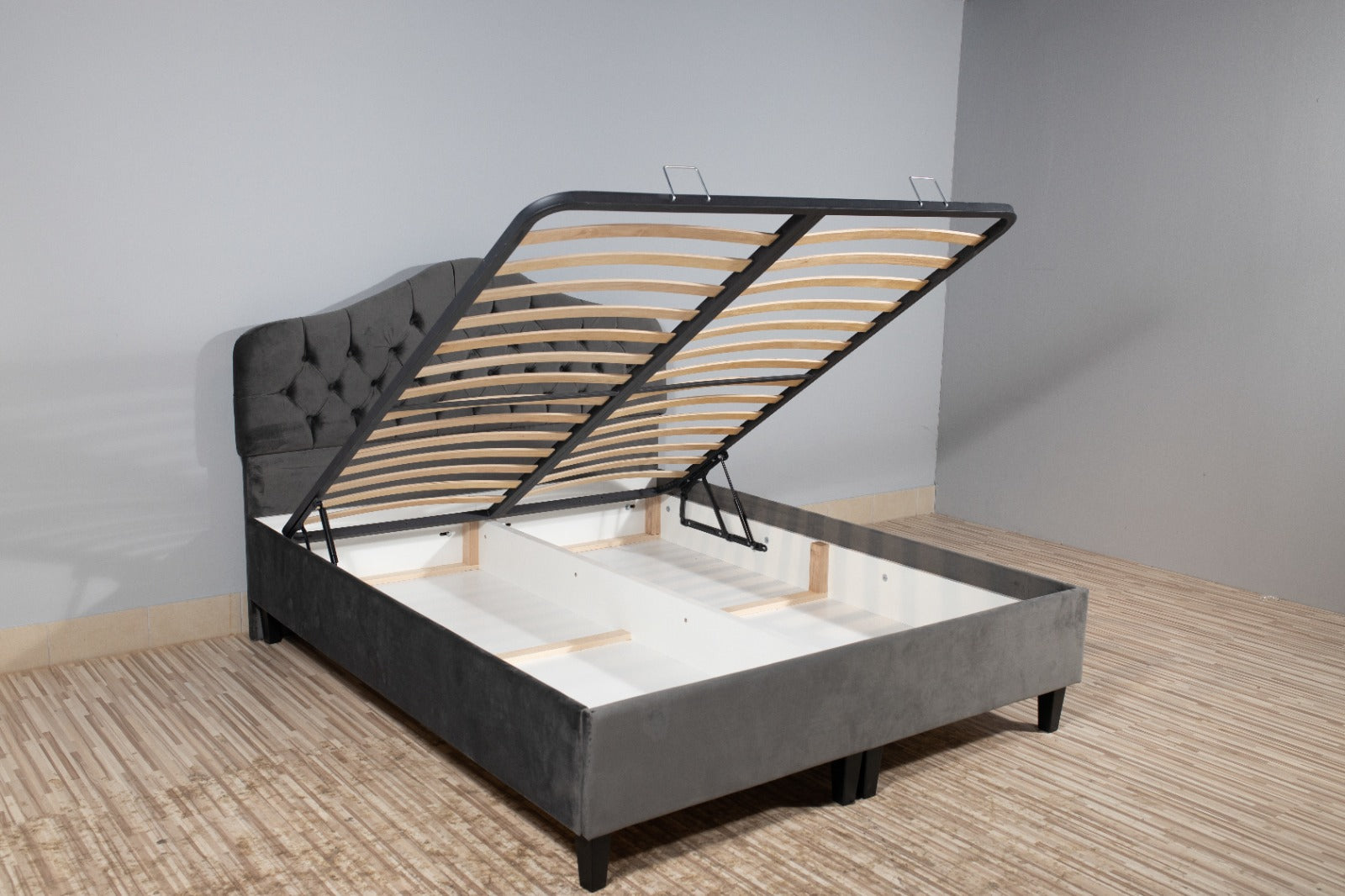 The image features a wooden bed frame, specifically the Dusk Ottoman Bed. It showcases a stylish design that complements the indoor setting, with elements its aesthetic.