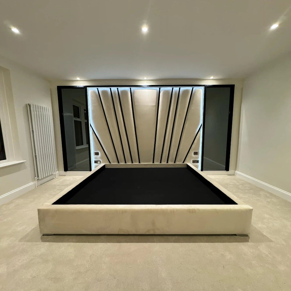 Modern bedroom with a backlit geometric headboard and a bed frame without a mattress.