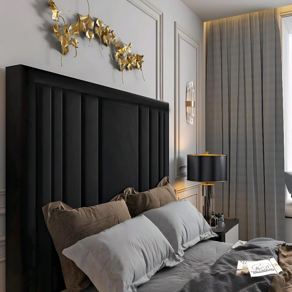 A bedroom with a black Alexander TV bed, gray bedding, golden leaf art, and a black lamp.