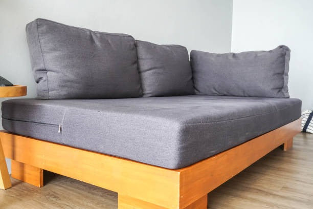 Modern gray bumo bed couch with wooden frame and cushions.